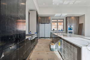 Kitchen with light stone countertops, modern cabinets, and appliances with stainless steel finishes