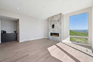 Unfurnished living room with light wood-style flooring, a fireplace, and recessed lighting