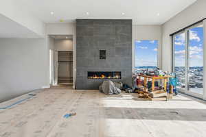 Living room featuring a tiled fireplace, recessed lighting, and wood finished floors