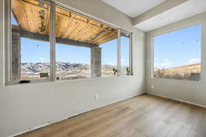 Spare room featuring wood ceiling, a mountain view, light wood-type flooring, and a wealth of natural light