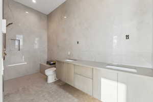 Bathroom featuring tile walls and toilet