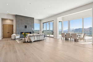 Living area featuring a mountain view, light wood-style flooring, a large fireplace, and recessed lighting