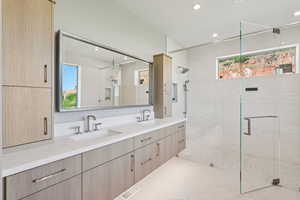 Full bath with a shower stall, double vanity, tile patterned floors, and recessed lighting