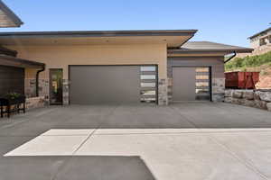 View of front of property with driveway, stone siding, and a garage