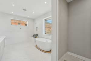 Full bath with recessed lighting, a freestanding tub, baseboards, and tile patterned floors