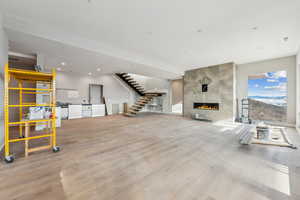 Living area with stairway, wood finished floors, visible vents, a fireplace, and recessed lighting