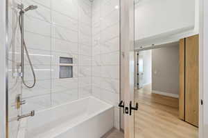 Bathroom featuring wood finished floors and shower / washtub combination