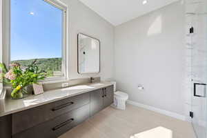 Full bath featuring vanity and a marble finish shower