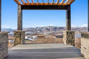 Snow covered deck featuring a mountain view