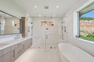 Full bath with plenty of natural light, a soaking tub, and recessed lighting