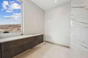 Bathroom featuring baseboards and lofted ceiling