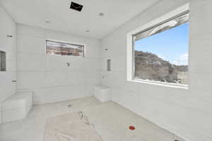 Bathroom featuring tile patterned flooring, plenty of natural light, and tile walls