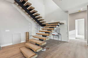 Stairs featuring recessed lighting, baseboards, and wood finished floors