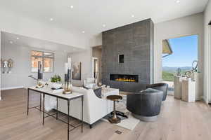 Living room with light wood-style flooring, a tile fireplace, plenty of natural light, recessed lighting, and a mountain view
