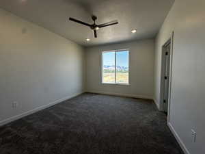 Spare room with carpet, ceiling fan, and a textured ceiling