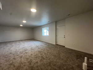 Unfurnished room featuring dark colored carpet