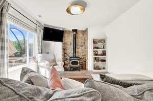 Living room with a wood stove and wood-style LVT floors