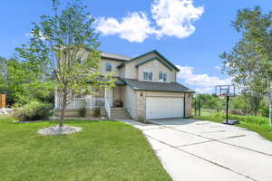 View of front of home featuring a garage and a front yard