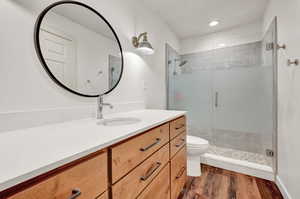 Bathroom with a shower with shower door, vanity and toilet