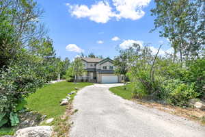 View of front of property featuring a garage and a front lawn