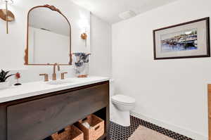 Bathroom featuring vanity, tile patterned flooring, and toilet