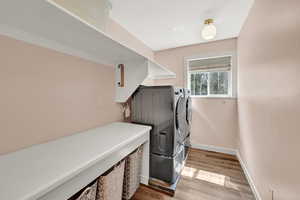 Laundry area featuring separate washer and dryer and light hardwood / wood-style floors