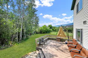 Wooden terrace with a lawn and outdoor lounge area