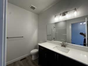 Bathroom featuring vanity, wood-type flooring, and toilet