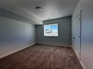 Carpeted empty room with a textured ceiling