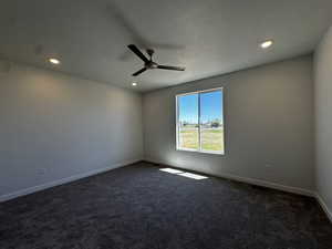 Carpeted spare room featuring a textured ceiling and ceiling fan