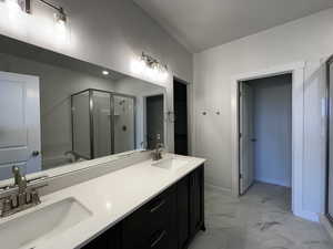 Bathroom featuring dual vanity, shower with separate bathtub, and tile patterned flooring