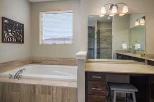 Bathroom featuring plus walk in shower and vanity