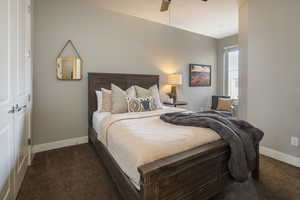 Carpeted bedroom featuring ceiling fan and a closet