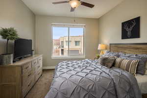 Carpeted bedroom featuring ceiling fan