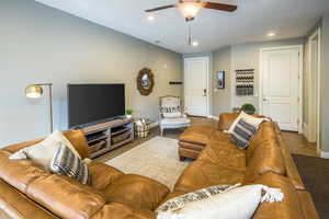 Living room with light colored carpet and ceiling fan