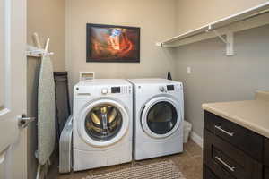 Washroom featuring washer and clothes dryer and tile patterned floors