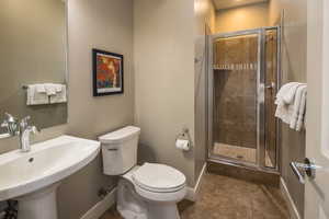 Bathroom featuring sink, toilet, tile patterned flooring, and walk in shower