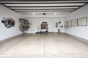 Garage featuring electric panel and a garage door opener