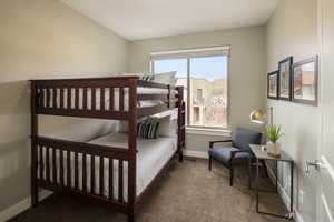 Carpeted bedroom featuring multiple windows