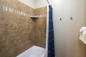 Bathroom with shower / bathtub combination with curtain