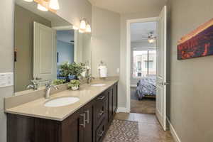 Bathroom featuring tile patterned flooring, ceiling fan, and double sink vanity