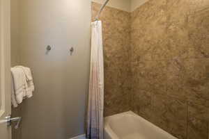 Bathroom featuring shower / bathtub combination with curtain