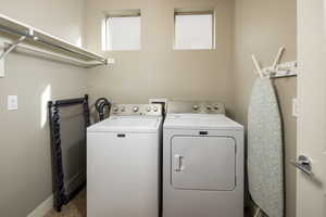 Clothes washing area featuring a healthy amount of sunlight and washing machine and clothes dryer