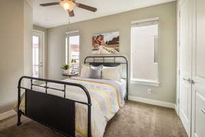 Carpeted bedroom with a closet and ceiling fan