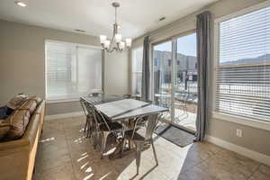 Tiled dining space featuring an inviting chandelier