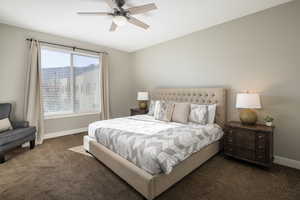 Carpeted bedroom featuring ceiling fan