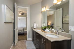 Bathroom featuring ceiling fan, vanity, and tile patterned flooring