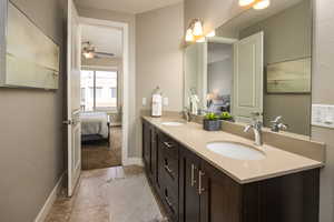 Bathroom with double vanity, tile patterned floors, and ceiling fan