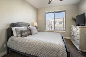 Carpeted bedroom with ceiling fan and lofted ceiling