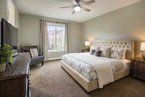 Carpeted bedroom featuring ceiling fan